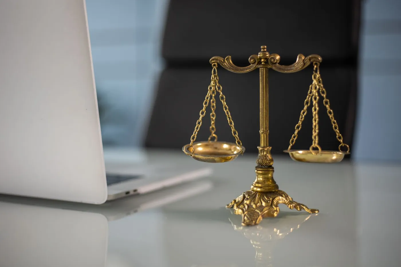Balanza de la justicia junto a una laptop