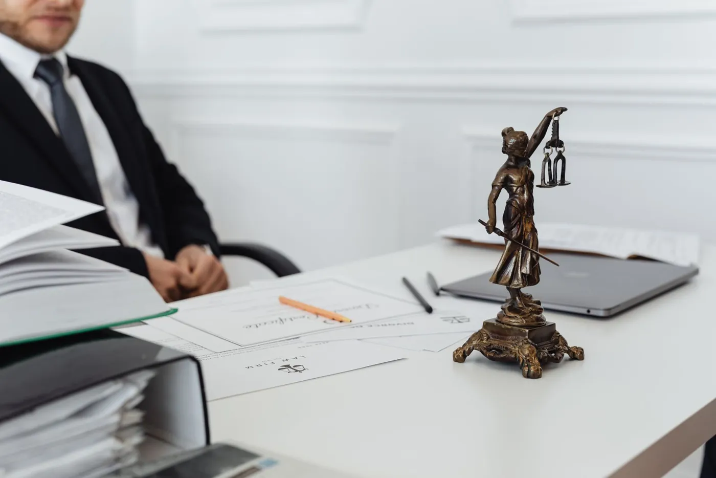 Escritorio de un estudio jurídico con la estatua de la justicia